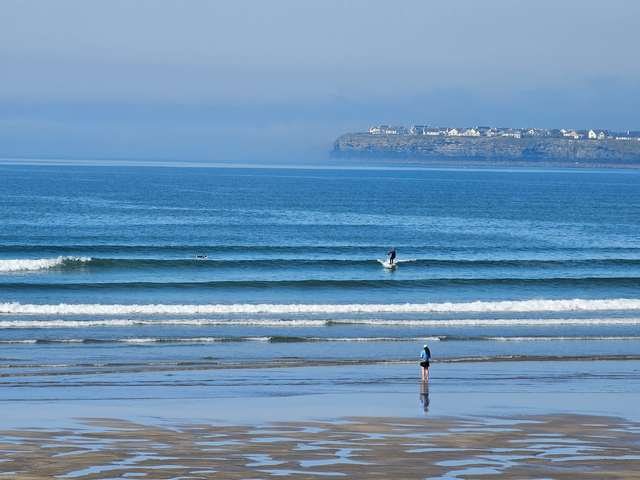 Surfer on a knee high wave in the middle of the beach